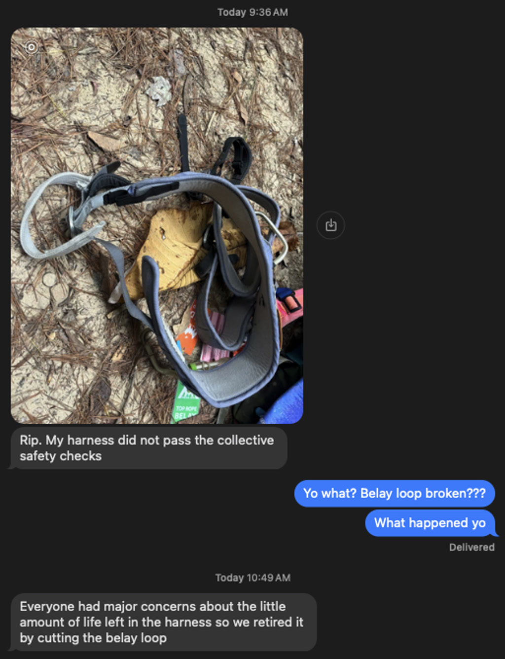 A climbing harness is shown with its belay loop intentionally cut, indicating the harness has been retired from use due to safety concerns. The harness is laid out on the ground, which is covered with dry pine needles and debris. There's also a glimpse of additional climbing gear next to the harness. A screenshot of a text message conversation is overlaid on the photo. The conversation is between two people discussing the retirement of the harness due to safety checks.