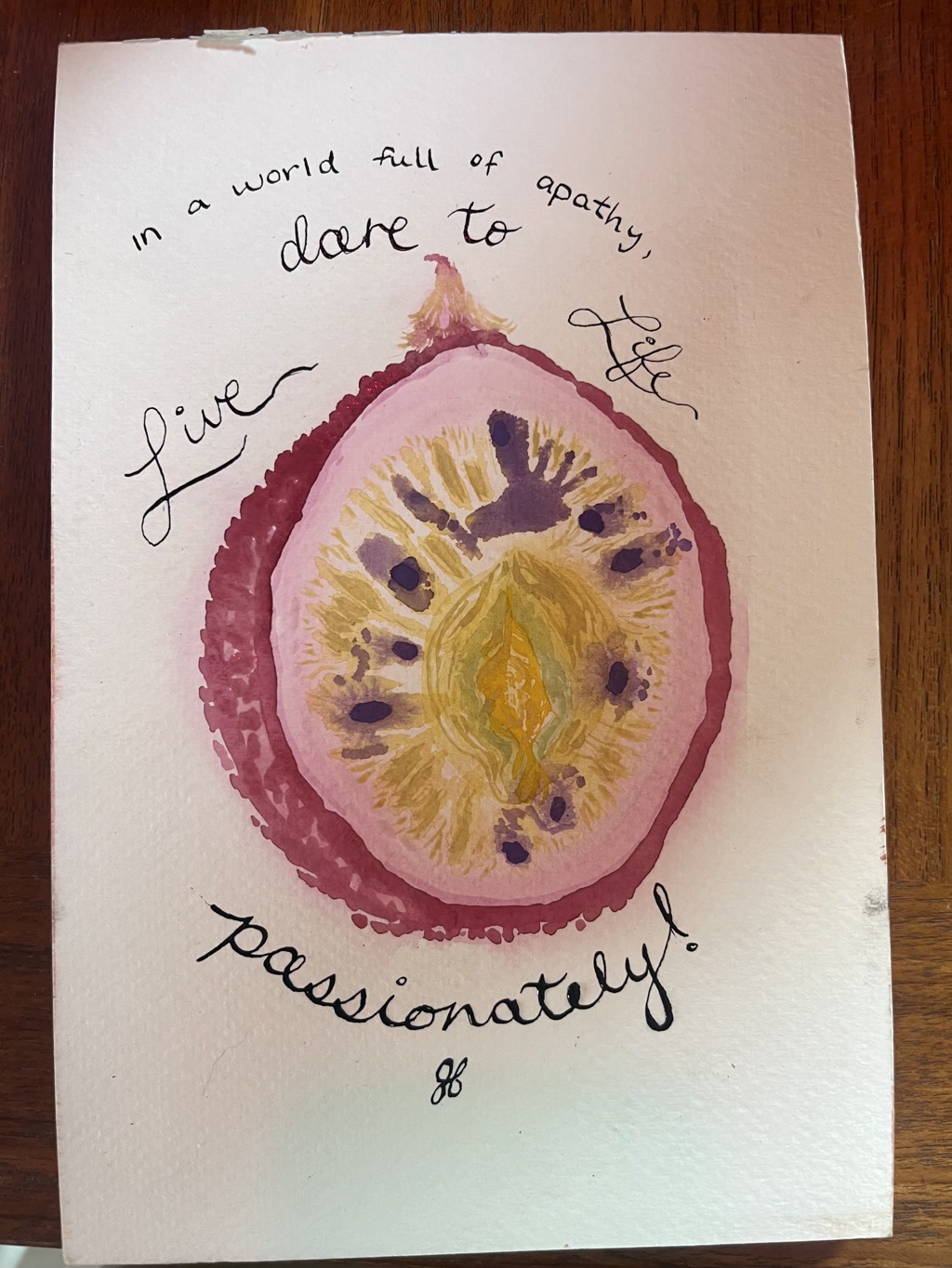 A watercolor painting depicts a passion fruit cut in half, revealing its seed-filled center, which is creatively integrated with the likeness of female genitalia. The art is imbued with rich hues of purple, yellow, and red, illustrating the inner part of the fruit. Surrounding the central depiction is a handwritten message that encourages living passionately as a counter to apathy.